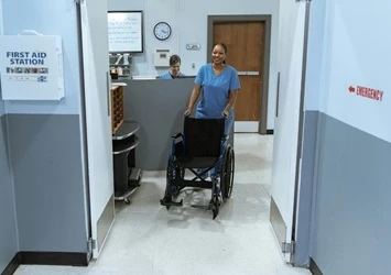 Nurse pushing wheelchair in hospital