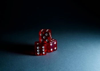 3 red dice on black background