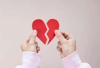 hand holding two pieces of a broken heart