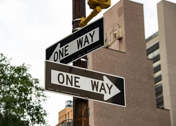 2 one way signs pointing in opposite directions
