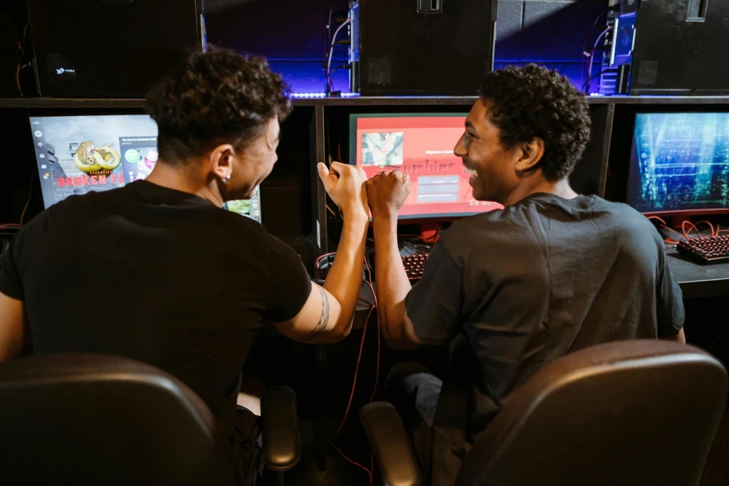 two gamers fist bumping in front of their screens