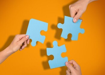 people putting jigsaw pieces together