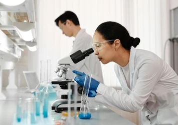 5 must-haves for electronic batch records - PEX Network woman looking at microscope