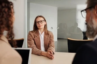 Young woman attending a job interview in a modern office, showcasing confidence and professionalism