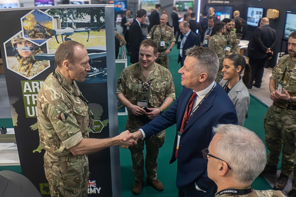 Military and industry delegates meeting on the IAV exhibition floor