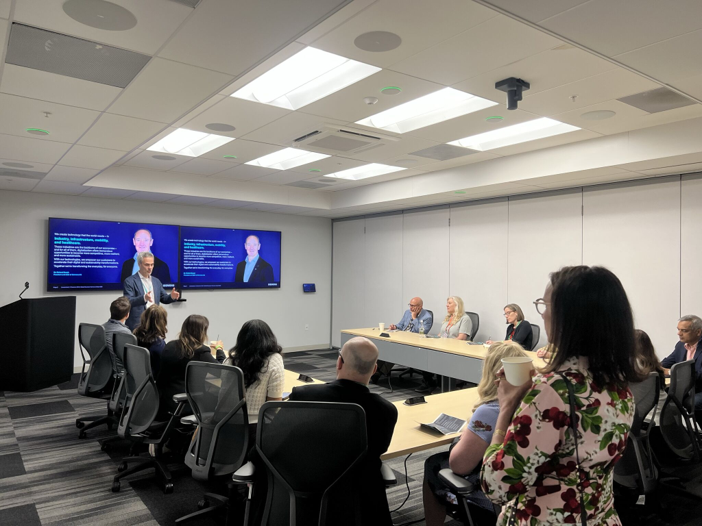 Executive presenting during Siemens roundtable with dual displays