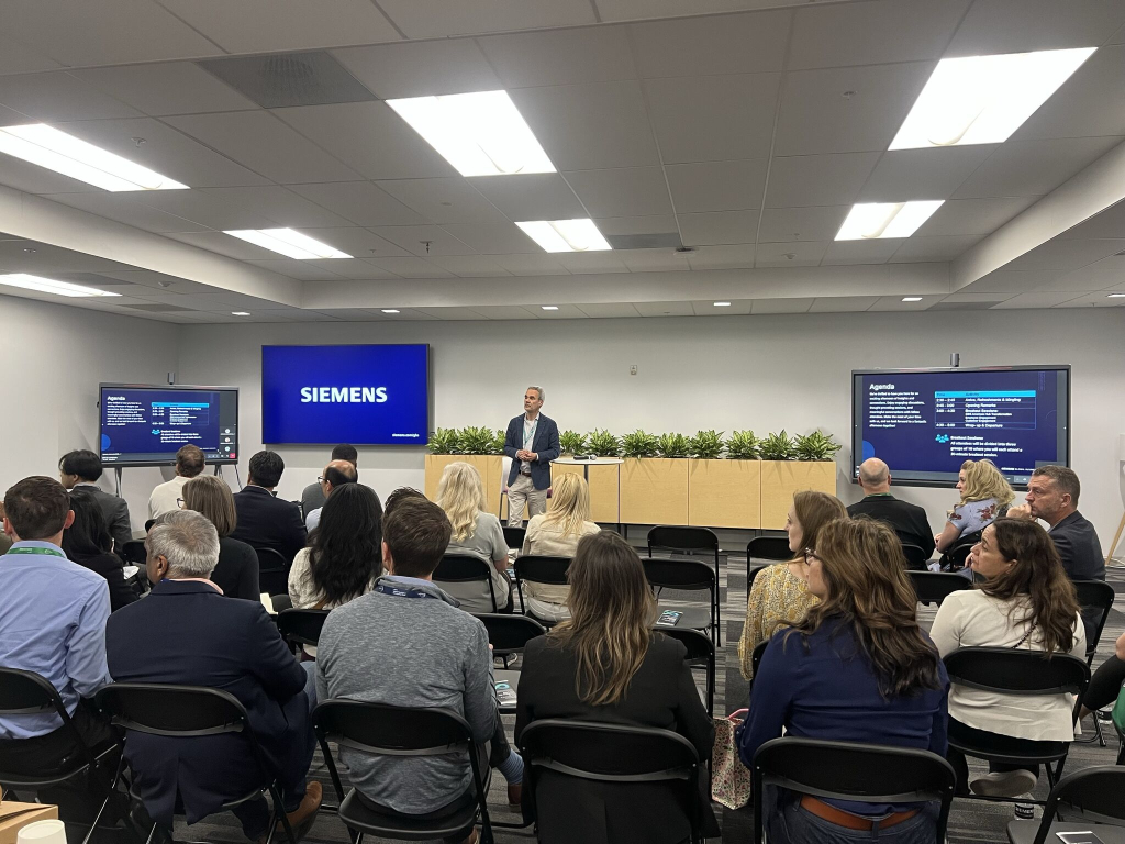 Attendees at Siemens session with presenter and agenda screens